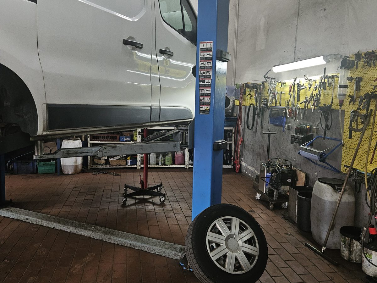 Transporter auf der Hebebühne, dahinter die Werkzeugwand